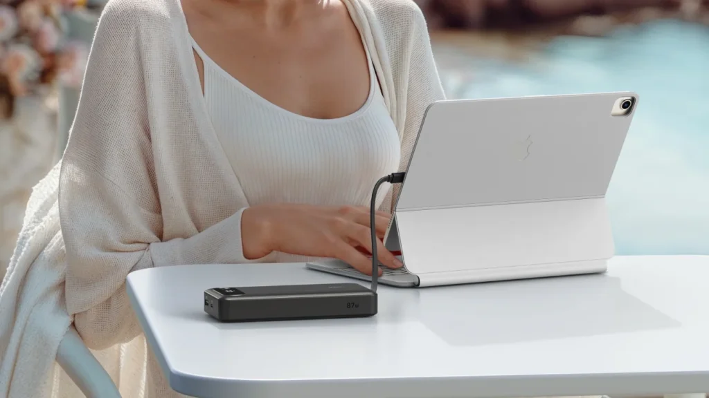 Γυναίκα σε διακοπές φορτίζει το tablet της από power bank Anker